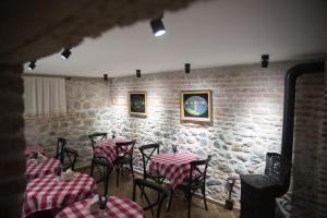 a room with tables and chairs and a brick wall at Old Bazaar Rooms in Korçë