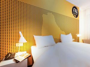 a bedroom with a bed and a phone and a wall at Hotel Ibis Styles La Rioja Arnedo in Arnedo