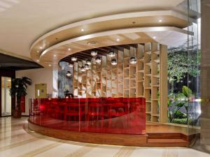 a lobby with red chairs and a glass wall at Ibis Styles Jakarta Airport in Tangerang