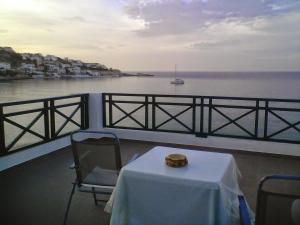 a table and chairs on a balcony overlooking the water at Armenistis View Studios in Armenistis