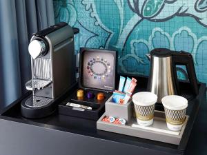 a desk with a cup of coffee and a coffee mug on it at Mercure Paris Bastille Saint Antoine in Paris