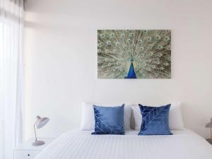 a bedroom with a bed with a peacock painting on the wall at The Sebel Launceston in Launceston +37 photos