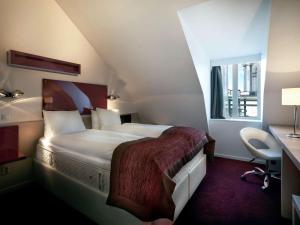 a hotel room with a large bed and a desk at Ibis Styles Stockholm Odenplan in Stockholm