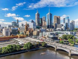a city skyline with a bridge and a river at Quay West Suites Melbourne in Melbourne