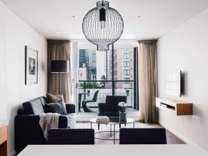 a living room with a couch and a table at Quay West Suites Melbourne in Melbourne