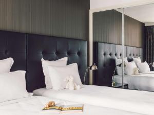 a bedroom with two beds with a teddy bear sitting on them at Quay West Suites Melbourne in Melbourne