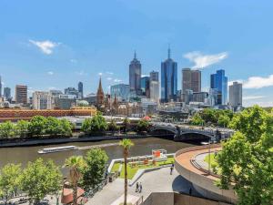a city skyline with a river and a bridge at Quay West Suites Melbourne in Melbourne