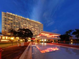 un hotel con piscina frente a un edificio en Sofitel Abidjan Hotel Ivoire, en Abiyán