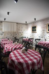 a restaurant with red and white checkered tables and chairs at Old Bazaar Rooms in Korçë