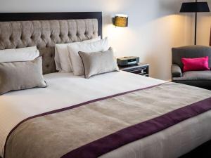 a bedroom with a large bed and a chair at Sofitel Buenos Aires Recoleta in Buenos Aires