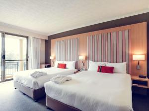 a hotel room with two beds and a window at Mercure Gold Coast Resort in Gold Coast