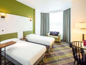 Pokój hotelowy z 2 łóżkami i krzesłem w obiekcie ibis Styles Edinburgh St Andrew Square w Edynburgu