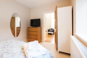 a bedroom with a bed and a mirror and a tv at Luxury 2 Bedroom Apartment in Peaceful Location in Cardiff
