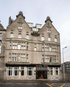 un grand bâtiment au coin d'une rue dans l'établissement The Station Hotel, à Aberdeen