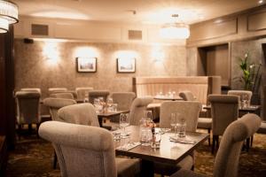 a restaurant with tables and chairs in a room at The Station Hotel in Aberdeen