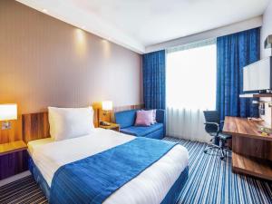 une chambre d'hôtel avec un lit et une chaise dans l'établissement ibis Styles Wałbrzych, à Wałbrzych
