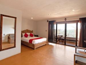 1 dormitorio con cama y espejo grande en Hotel Villa Xtreme, en Villa del Carbón