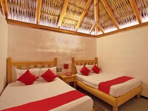 a bedroom with two beds with red and white sheets at Hotel Vista del Bosque, Villa del Carbón in Villa del Carbón