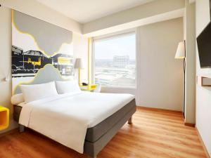 A bed or beds in a room at KIMAYA Braga Bandung by HARRIS