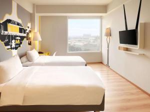 A bed or beds in a room at KIMAYA Braga Bandung by HARRIS