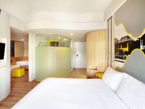 A bed or beds in a room at KIMAYA Braga Bandung by HARRIS
