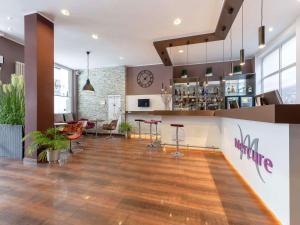a lobby with a bar and a restaurant at Mercure Frankfurt City Messe in Frankfurt