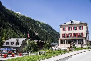 a building on the side of a road next to a mountain at Hôtel Le Besso - Swiss Romantic Lodge Zinal in Zinal