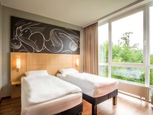 Una cama o camas en una habitación de ibis Wörthersee
