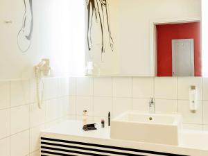 a white bathroom with a sink and a mirror at Ibis Styles Wroclaw Centrum in Wrocław