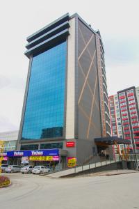 a large glass building with cars parked in front of it at Ramada by Wyndham Nigde in Nigde