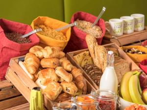 a bunch of different types of bread and other foods at ibis Styles Hotel Brussels Centre Stéphanie in Brussels