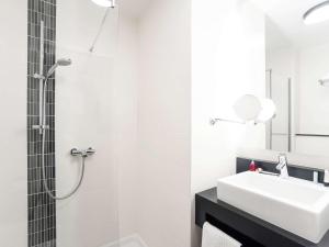 a white bathroom with a sink and a shower at ibis Styles Hotel Brussels Centre Stéphanie in Brussels