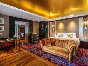 une chambre d'hôtel avec un lit et un canapé dans l'établissement Sofitel Singapore Sentosa Resort & Spa, à Singapour