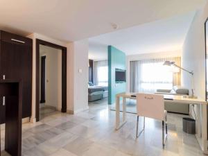 a living room with a table and a dining room at Mercure Algeciras in Algeciras