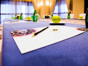 a table with a blue table cloth with a pen and a lemon at Grand Mercure Majlis Residences in Abu Dhabi