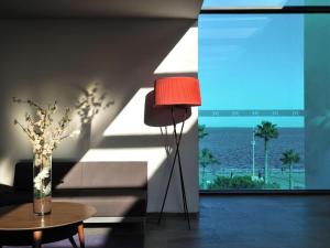 una lámpara roja en la sala de estar con vistas al océano en Mercure Nador Rif en Nador