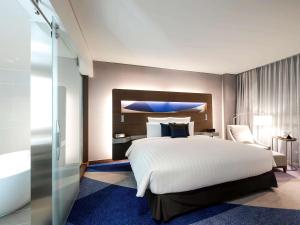 Un pat sau paturi într-o cameră la Novotel Ambassador Suwon