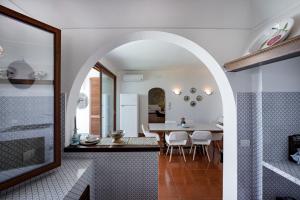 een keuken en eetkamer met een boog in een huis bij VILLA SOLEIL in Massa Lubrense