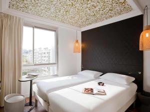 A bed or beds in a room at ibis Styles Paris Buttes Chaumont
