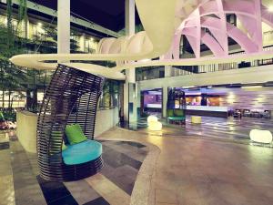 a lobby with a chair in the middle of a building at Mercure Bali Legian in Legian
