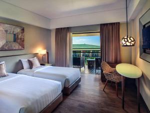 Postel nebo postele na pokoji v ubytování Mercure Bali Legian