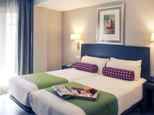 a hotel room with a bed with a tray of food on it at Mercure Madrid Centro in Madrid