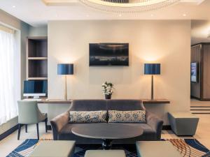 a living room with a couch and a table at Mercure Edinburgh Haymarket in Edinburgh