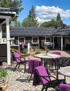 a patio with purple chairs and tables in front of a building at Gammelgården in  Högfjället