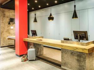 a lobby with a reception desk and a suitcase at Ibis Berlin Hauptbahnhof in Berlin