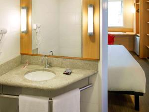 a bathroom with a sink and a mirror at ibis Imperatriz in Imperatriz