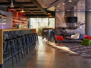 un bar avec des chaises et des tables dans un restaurant dans l'établissement Ibis Los Mochis, à Los Mochis