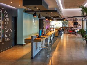 a bar in a restaurant with a desk and chairs at Ibis Los Mochis in Los Mochis