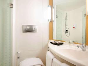 biała łazienka z umywalką i toaletą w obiekcie Ibis Bandung Pasteur w mieście Bandung