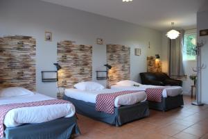 a hotel room with two beds and a couch at Hotel La Peyrade in Cajarc